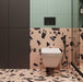Contemporary bathroom featuring Chunks Rock Pink 60cm x 120cm terrazzo effect porcelain wall and floor tiles, paired with mint green wall tiles, black brassware, a walk-in shower and minimalist furnishings.