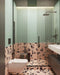 Contemporary bathroom featuring Chunks Rock Pink 60cm x 120cm terrazzo effect porcelain wall and floor tiles, paired with mint green wall tiles, black brassware, a walk-in shower and minimalist furnishings.