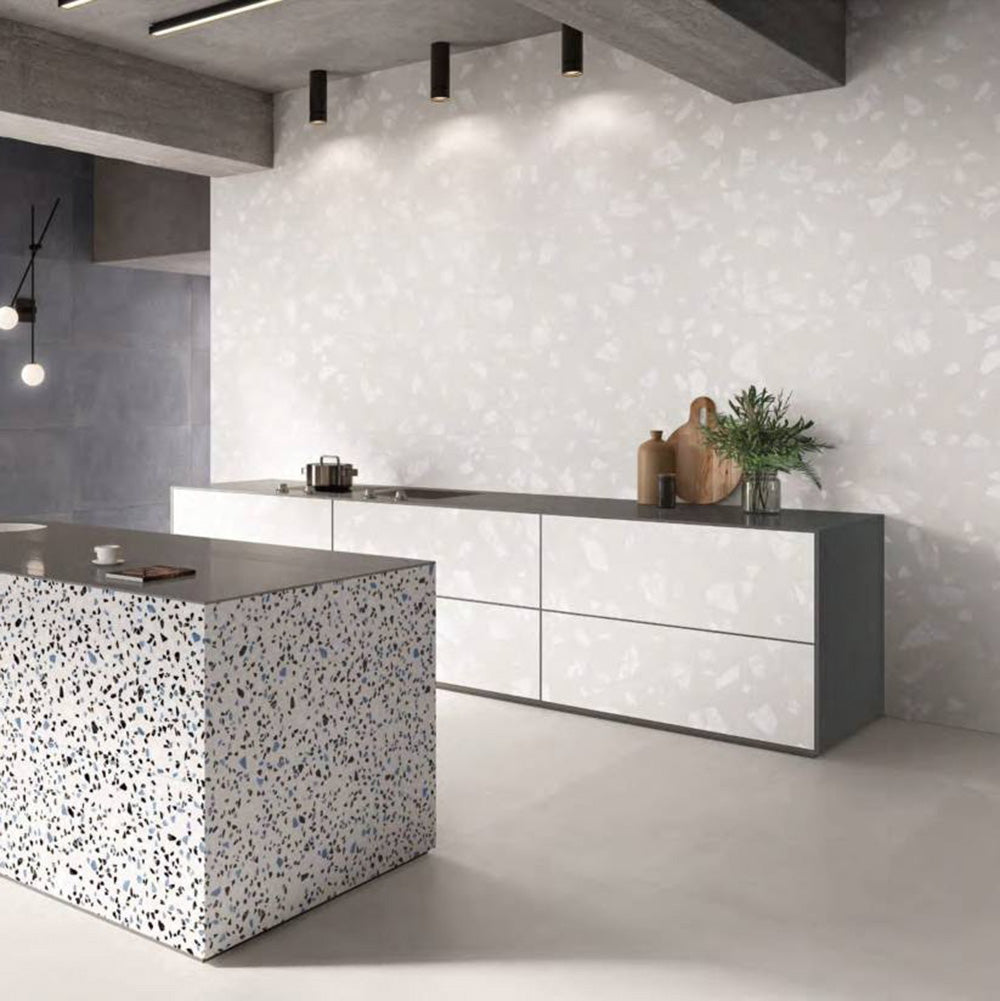 Contemporary kitchen featuring Chunks ROCK Terrazzo White 60 × 120cm terrazzo-effect porcelain wall tiles, paired with minimalist grey cabinetry, concrete ceilings, and a statement terrazzo kitchen island for a sleek modern interior.