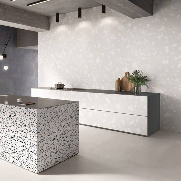 Contemporary kitchen featuring Chunks ROCK Terrazzo White 60 × 120cm terrazzo-effect porcelain wall tiles, paired with minimalist grey cabinetry, concrete ceilings, and a statement terrazzo kitchen island for a sleek modern interior.