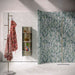 Bathroom featuring Chunks Rock Terrazzo White 60x60cm terrazzo-effect porcelain wall and floor tiles, styled with a curved shower wall, green patterned feature tiles, brushed brass fixtures and soft contemporary décor.
