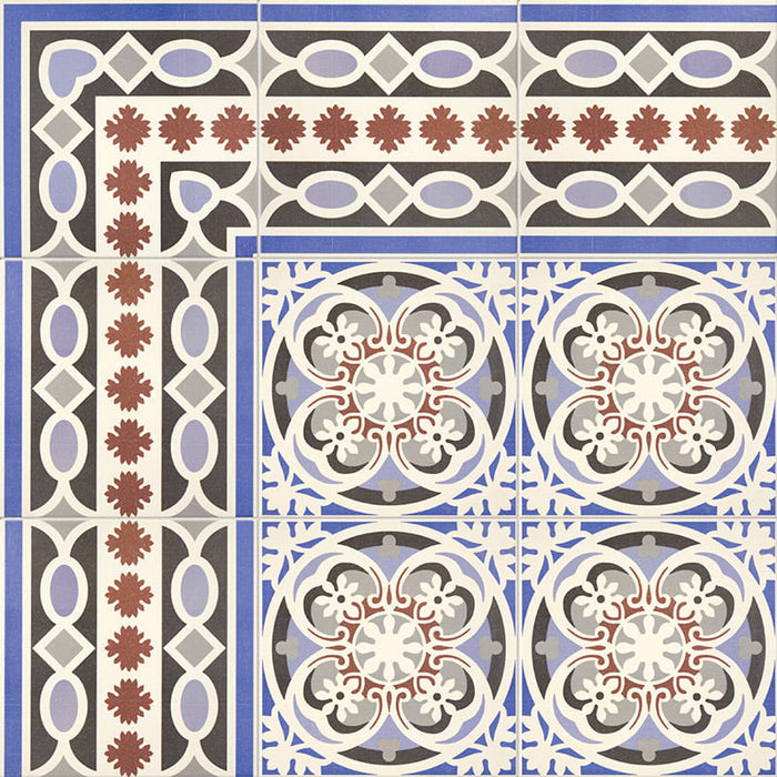 Empire Blue 15x15cm Victorian border tile close-up showing intricate interlocking ovals and leaf motifs in blue, terracotta, white, and charcoal tones, paired with the matching patterned floor tiles for a traditional heritage look.