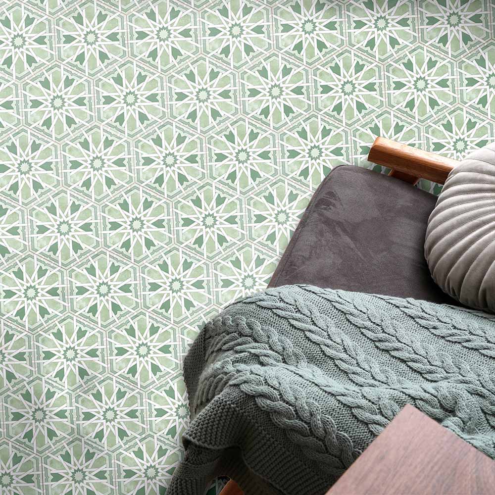 Maroush Mareshan Verde Green 18.7x21.6cm Moroccan hexagonal tiles featuring intricate white geometric star patterns, styled in a cosy chair setting with soft textiles and natural green tones for a relaxing interior look.
