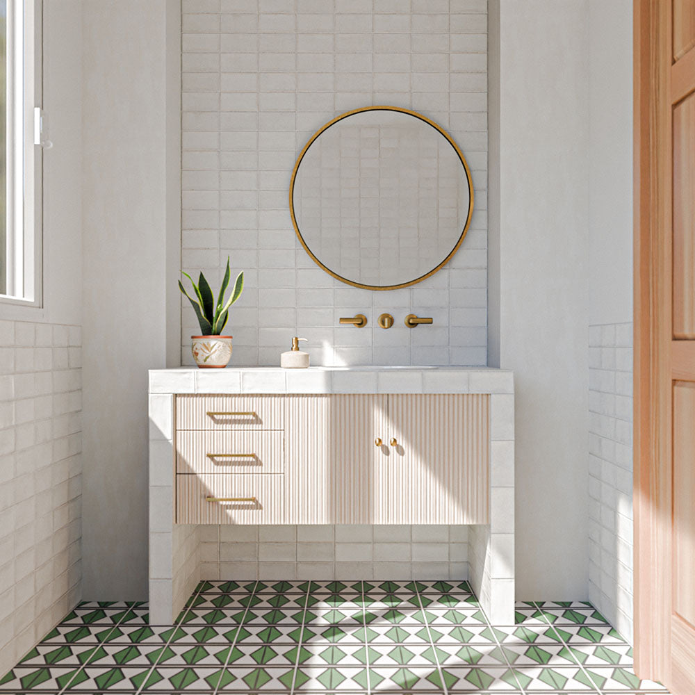 Bathroom featuring Cotswolds Rustic White Blanca 7.5cm x 15cm rustic gloss wall tiles, showcasing soft white tones and subtle surface variation, paired with green geometric floor tiles, a fluted vanity and brass details.