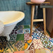 Bathroom setting featuring Fihrdos Patchwork Moroccan-style 20x20cm patterned porcelain floor tiles, combining colourful geometric designs beneath a freestanding bath and teal wall tiles.