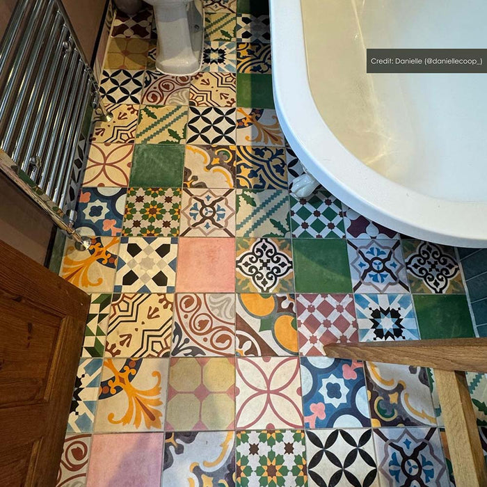 Bathroom setting featuring Fihrdos Patchwork Moroccan-style 20x20cm patterned porcelain floor tiles, combining colourful geometric designs beneath a freestanding bath and teal wall tiles.