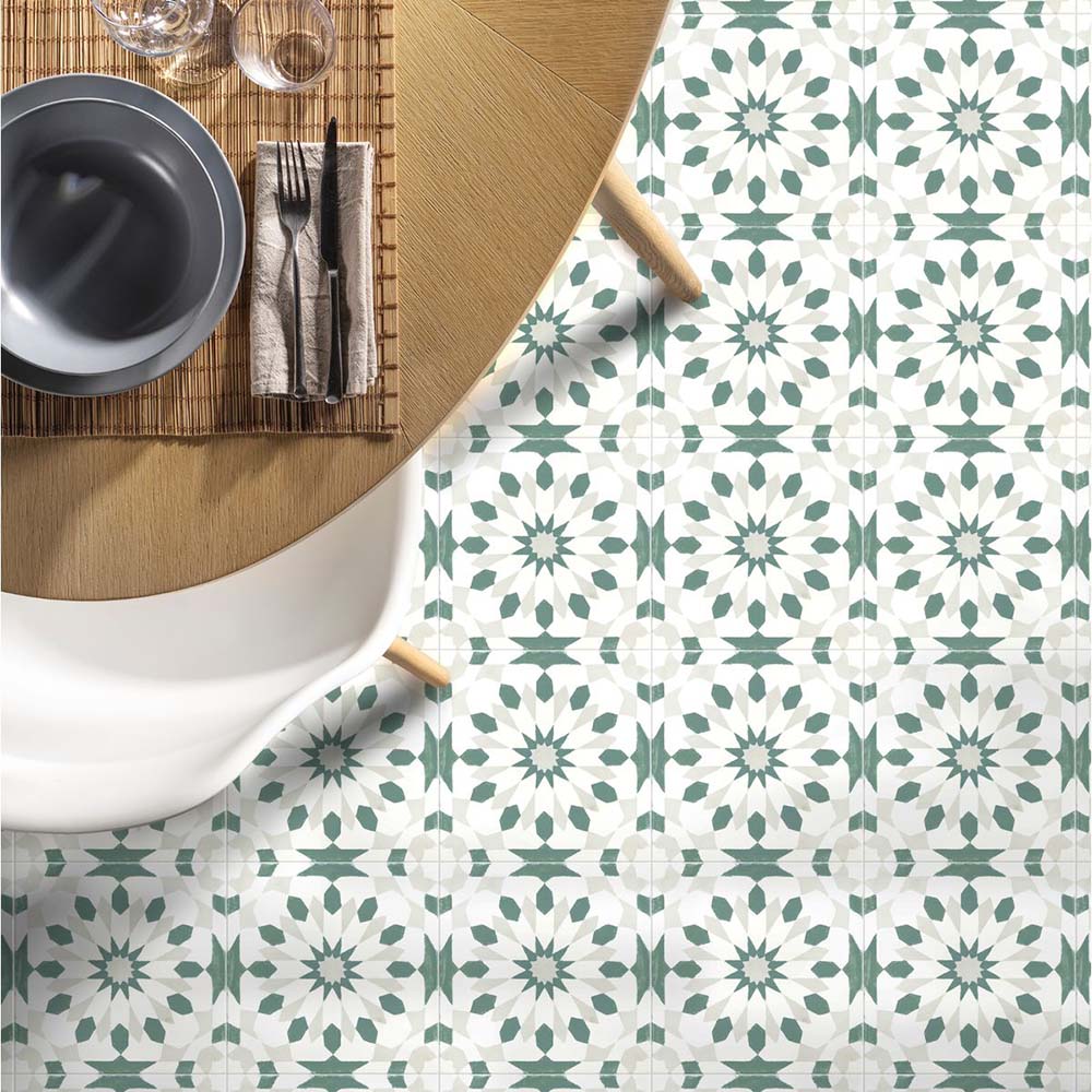 Dining room featuring Soukaina Green A Moroccan-style 20cm x 20cm patterned porcelain floor tiles, with a soft green and white geometric design styled beneath a round wooden dining table.