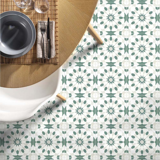 Dining room featuring Soukaina Green A Moroccan-style 20cm x 20cm patterned porcelain floor tiles, with a soft green and white geometric design styled beneath a round wooden dining table.