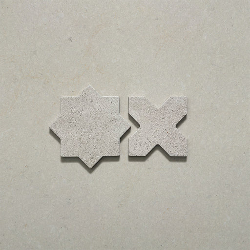 Close-up of Dohar Avorio Rocks Star & Cross porcelain wall and floor tiles, showcasing the coordinating geometric shapes, soft ivory colour, fine speckled detail and textured matt finish.