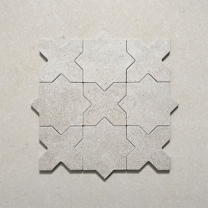 Close-up of Dohar Avorio Rocks Star & Cross porcelain wall and floor tiles, arranged in an interlocking geometric pattern with soft ivory tones, subtle speckled detail and a textured matt finish.