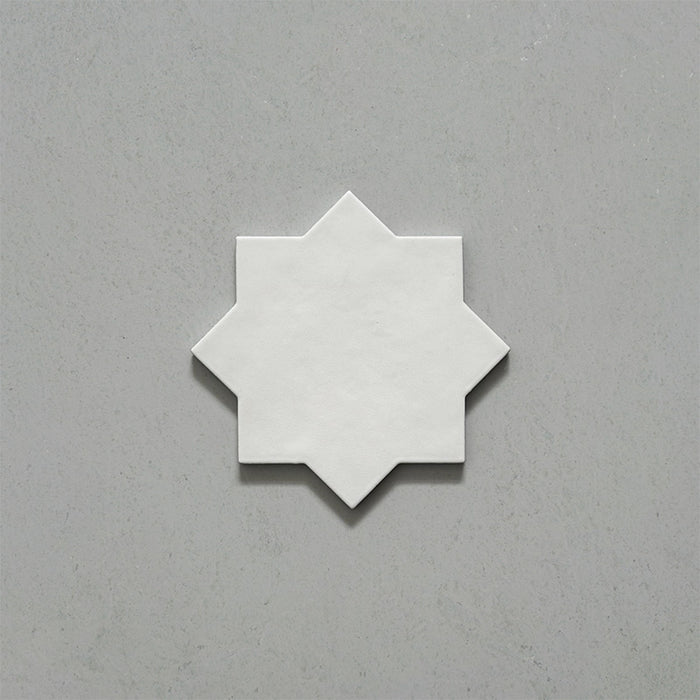 Close-up of a single Dohar Bone Star Moroccan style porcelain wall and floor tile, showcasing the distinctive eight-point star shape, soft off-white tone and subtle matt finish.