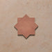 Close-up of a single Dohar Cotto Star Moroccan style porcelain wall and floor tile, showcasing the distinctive eight-point star shape, warm terracotta tone and soft matt finish.