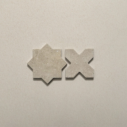 Close-up of Dohar Sands Star and Cross porcelain wall and floor tiles, showcasing the complementary geometric shapes, warm sandy beige tones, speckled surface detail and subtle matt finish.