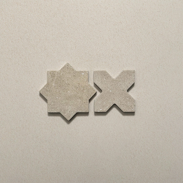 Close-up of Dohar Sands Star and Cross porcelain wall and floor tiles, showcasing the complementary geometric shapes, warm sandy beige tones, speckled surface detail and subtle matt finish.