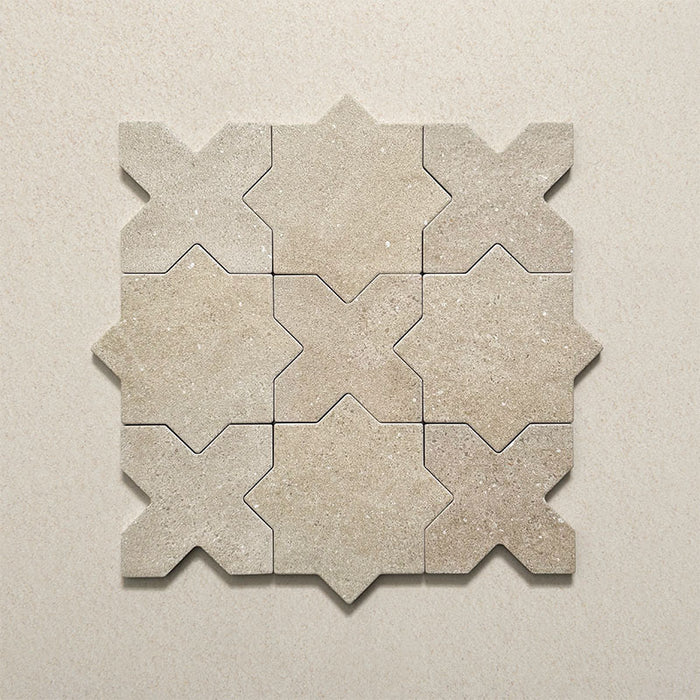 Close-up of Dohar Sands Star and Cross porcelain wall and floor tiles, showcasing the interlocking geometric design, warm sandy beige tones, speckled surface detail and subtle matt finish.