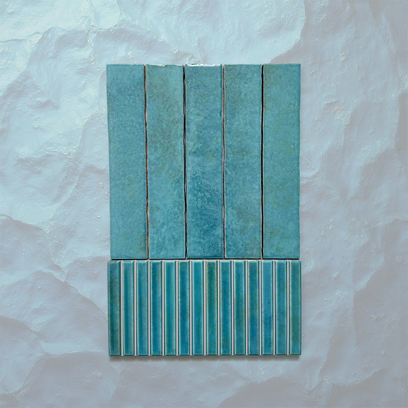 Product display of Elazar Decor Azul Blue 12.5x25cm ceramic wall tiles in vibrant blue tones, featuring a handcrafted glossy finish with coordinating fluted decorative tiles for textured contemporary interiors.