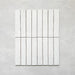 Product display of Elazar Blanco 5x25cm glossy wall tiles in soft white tones, featuring handcrafted edges and subtle surface variation against a textured plaster-style backdrop.