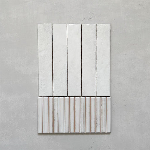 Product display of Elazar Decor Blanco 12.5x25cm ceramic wall tiles in soft white tones, featuring a handcrafted glossy finish with coordinating fluted decorative tiles for textured contemporary interiors.