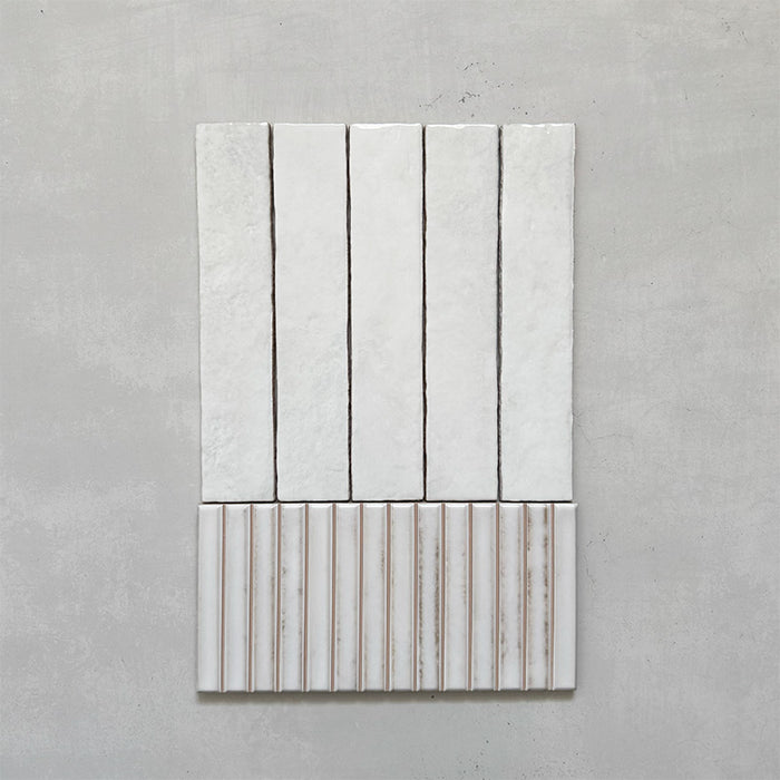 Product display of Elazar Decor Blanco 12.5x25cm ceramic wall tiles in soft white tones, featuring a handcrafted glossy finish with coordinating fluted decorative tiles for textured contemporary interiors.