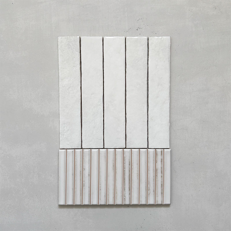 Product display of Elazar Decor Blanco 12.5x25cm ceramic wall tiles in soft white tones, featuring a handcrafted glossy finish with coordinating fluted decorative tiles for textured contemporary interiors.