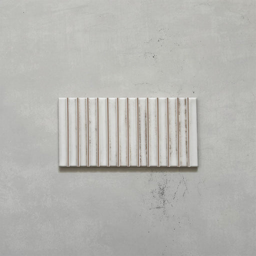 Product display of Elazar Decor Blanco 12.5x25cm ceramic wall tiles in soft white tones, featuring a linear fluted design, handcrafted glossy finish and subtle tonal variation for textured contemporary interiors.