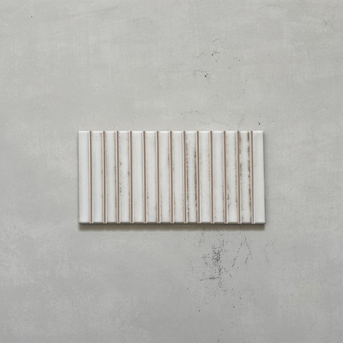 Product display of Elazar Decor Blanco 12.5x25cm ceramic wall tiles in soft white tones, featuring a linear fluted design, handcrafted glossy finish and subtle tonal variation for textured contemporary interiors.