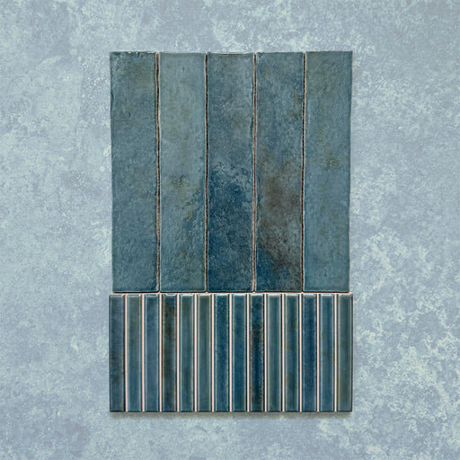Product display of Elazar Decor Prussian 12.5x25cm ceramic wall tiles in deep blue tones, featuring a handcrafted glossy finish with coordinating fluted decorative tiles for textured contemporary interiors.