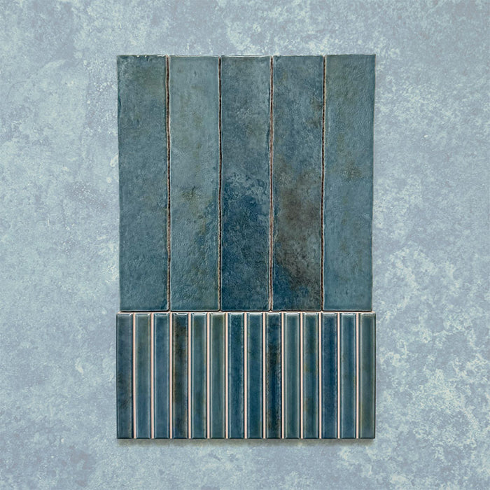 Product display of Elazar Decor Prussian 12.5x25cm ceramic wall tiles in deep blue tones, featuring a handcrafted glossy finish with coordinating fluted decorative tiles for textured contemporary interiors.