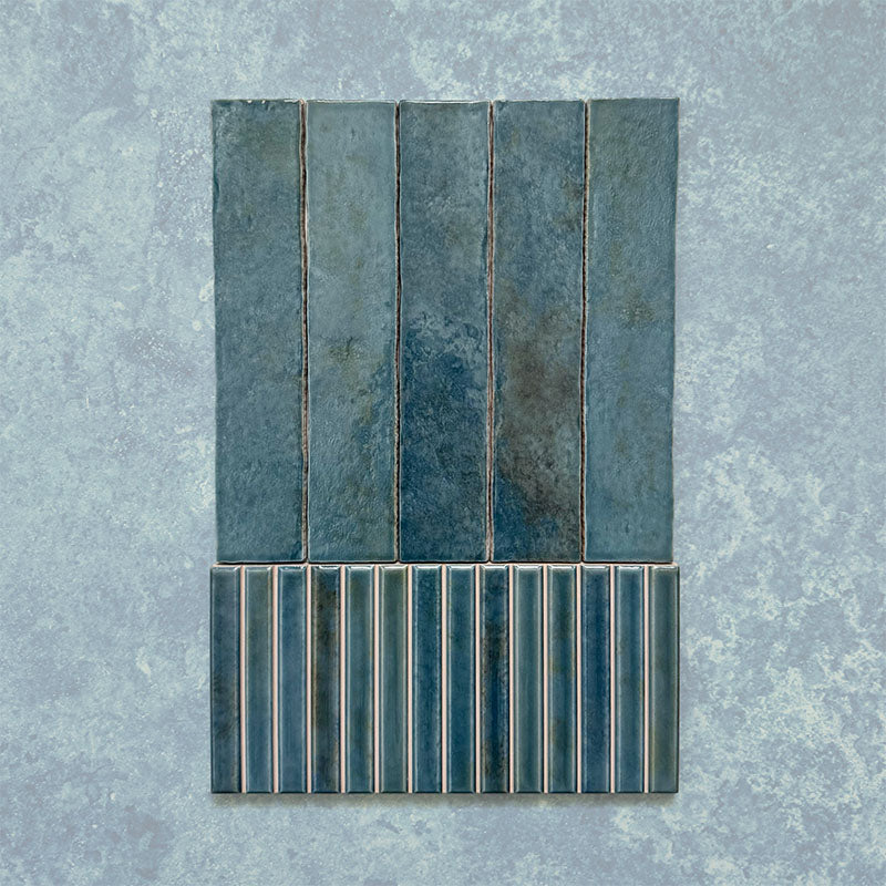 Product display of Elazar Decor Prussian 12.5x25cm ceramic wall tiles in deep blue tones, featuring a handcrafted glossy finish with coordinating fluted decorative tiles for textured contemporary interiors.
