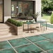 Outdoor patio featuring Elements Oxide 2cm thick porcelain floor tiles in a metallic effect finish, styled with contemporary garden furniture, timber-effect steps, built-in planters and modern landscaping for a luxurious outdoor living space.