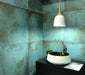 Contemporary bathroom featuring Elements Oxide 60cm x 60cm metallic effect wall tiles, styled with a black vanity, vessel basin, pendant lighting and rich blue-green tones for a modern industrial-inspired interior.