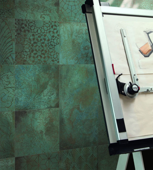 Contemporary workspace featuring Elements Oxide Patterns 30cm x 30cm metallic effect porcelain wall tiles, showcasing decorative etched patterns in rich blue-green tones behind a modern drawing board.
