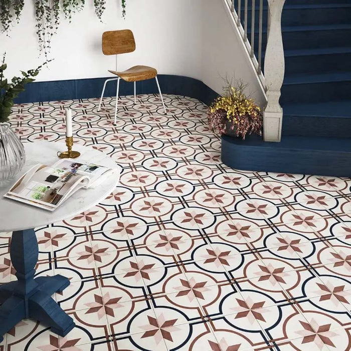 Entryway featuring Carnaby Rose Victorian-style 20x20cm porcelain wall and floor tiles, showcasing a pink and navy geometric pattern, styled with navy staircase details, trailing greenery, and minimalist wooden furniture.