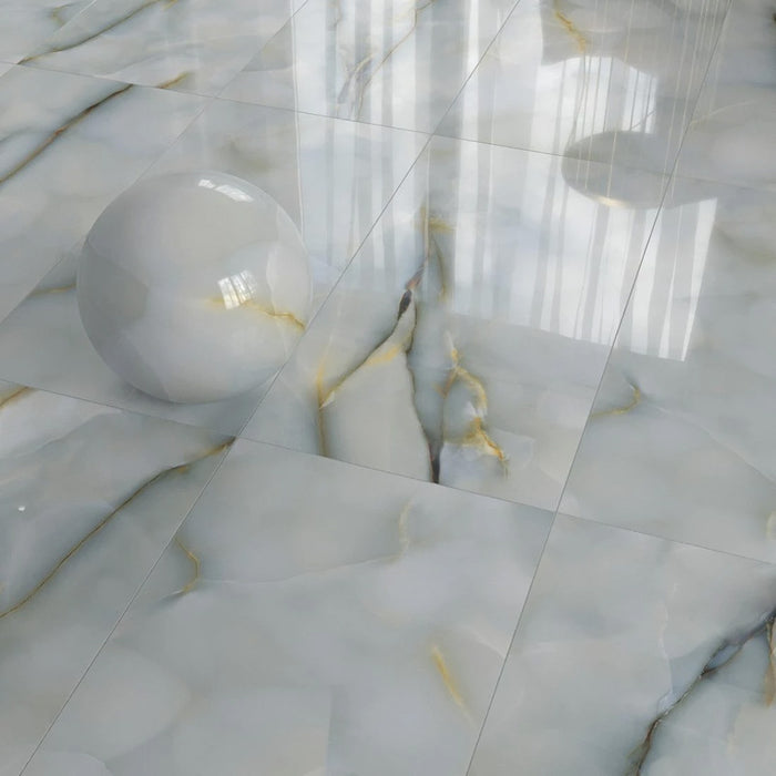 Flat lay of Fantasia Turchese Blue Onyx Polished 60 × 120cm stone effect floor tiles, arranged in a grid layout to showcase soft blue-grey tones, high-gloss finish, and flowing gold veining, styled with a decorative sphere to highlight the tile’s reflective surface and depth.