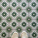 Top-down view featuring Clarence House Jade Mini 15x15cm Victorian Moroccan-style porcelain floor tiles, styled with cream trainers to highlight the soft green and white geometric pattern.