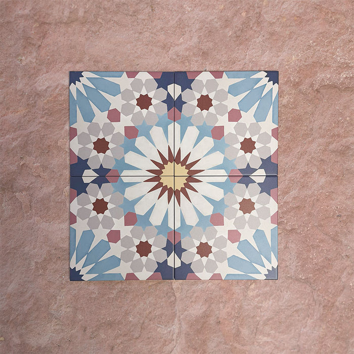 Arrangement of Fizaan Fiera 20x20cm Moroccan-style porcelain tiles, showcasing a repeating geometric pattern in soft blue, red and neutral tones.