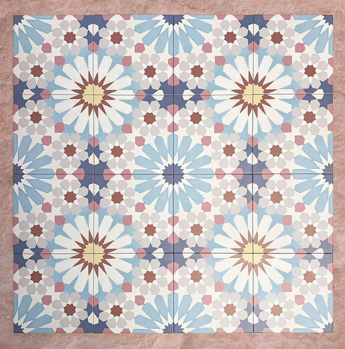 Arrangement of Fizaan Fiera 20x20cm Moroccan-style porcelain tiles, showcasing a repeating geometric pattern in soft blue, red and neutral tones.