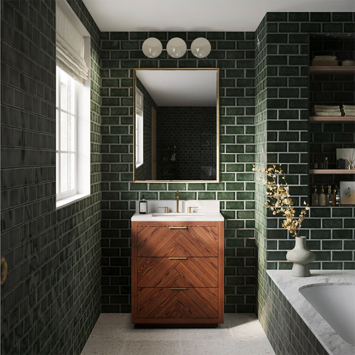 Bathroom featuring Finchley Golders Green 7.5x15cm crackle glaze wall tiles, showcasing deep glossy green tones laid in a brick pattern, paired with a herringbone walnut vanity, brass fittings, marble surfaces and built-in shelving for a timeless, luxurious finish.