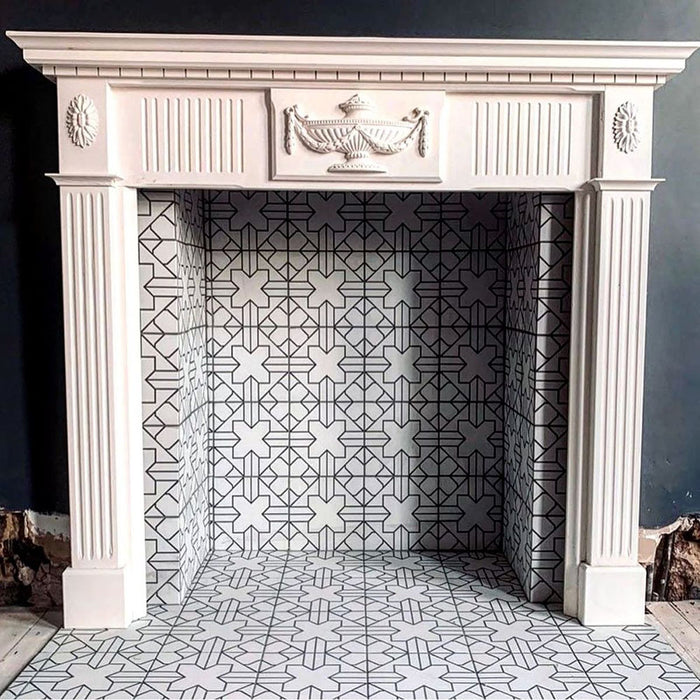 Alhambra Palacio 20x20cm Moroccan tiles styled inside a classic white fireplace, featuring an elegant black and white geometric cross pattern that adds a striking modern contrast to a traditional mantelpiece.