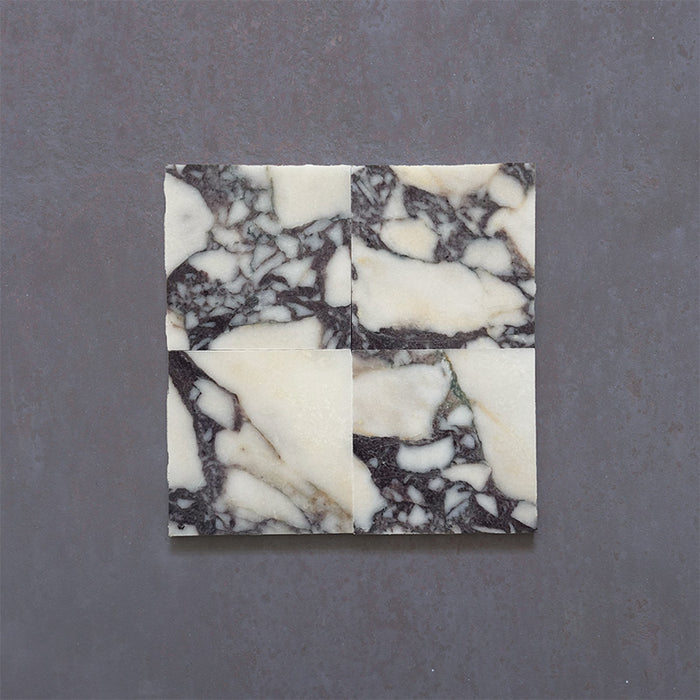 Fitzrovia Calacatta Viola honed natural marble tile in a 15.2cm x 15.2cm square format, featuring a creamy white background with bold purple veining and subtle warm gold tones, creating a luxurious and timeless natural stone finish.