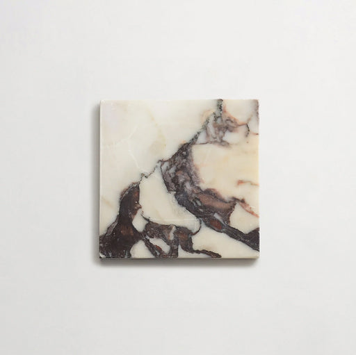 Close-up of Fitzrovia Calacatta Viola honed natural marble tile in a 15.2cm x 15.2cm square format, featuring a creamy white background with striking deep purple and warm gold veining, creating a luxurious and timeless natural stone finish.