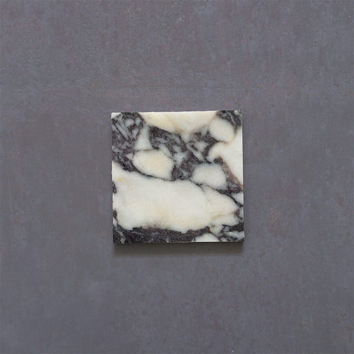 Close-up of Fitzrovia Calacatta Viola honed natural marble tile in a 15.2cm x 15.2cm square format, featuring a creamy white background with bold purple veining and subtle warm gold tones, creating a luxurious and timeless natural stone finish.