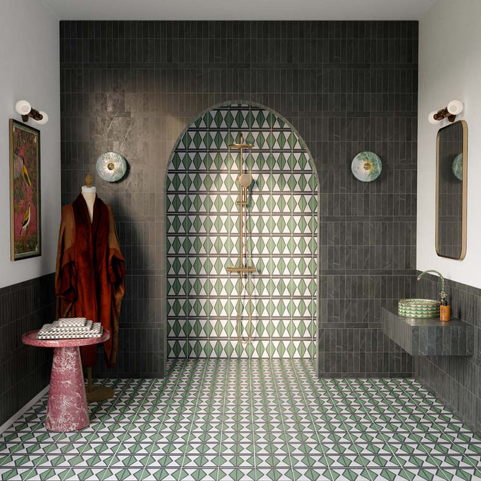 Bathroom featuring Fitzrovia Verde Honed Finish Natural Marble 5cm x 20cm wall tiles, paired with Geometry Hourglass patterned floor tiles, an arched walk-in shower, brushed brass fittings, a floating vanity and elegant green marble detailing.