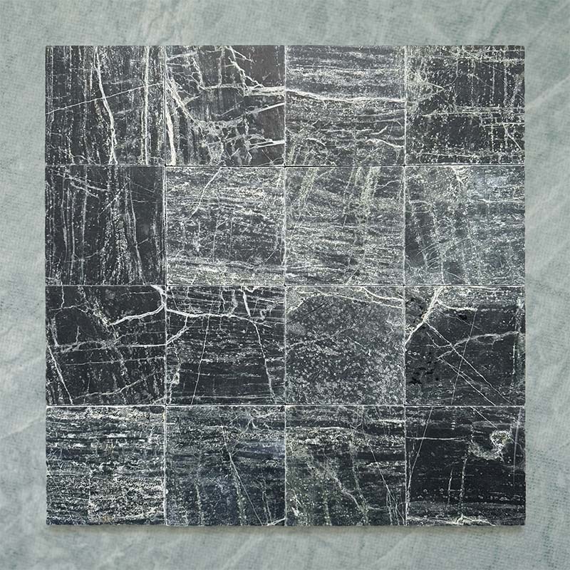 Fitzrovia Verde tumbled natural marble tile in a 15.2cm x 15.2cm square format, featuring deep forest green tones with natural white veining, textured tumbled edges and an authentic aged stone finish.