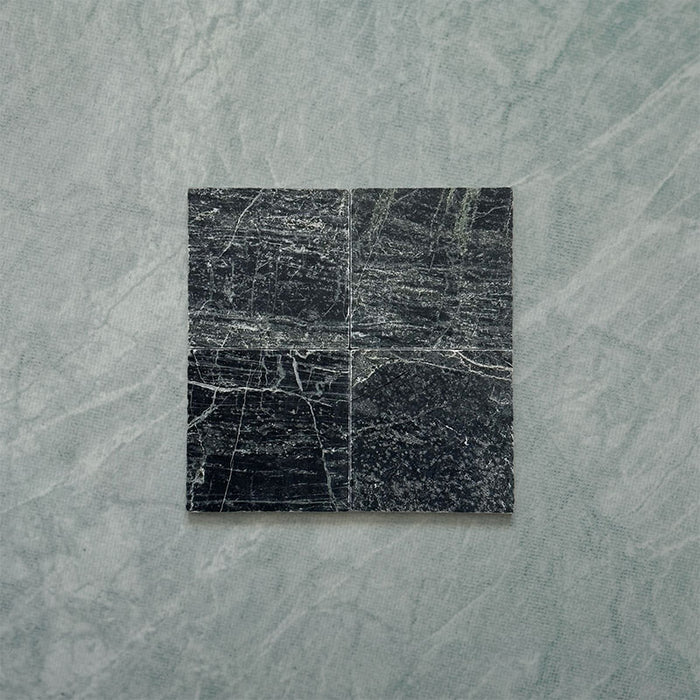 Fitzrovia Verde tumbled natural marble tile in a 15.2cm x 15.2cm square format, featuring deep forest green tones with natural white veining, textured tumbled edges and an authentic aged stone finish.