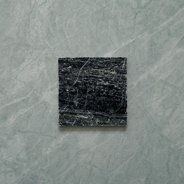 Close-up of Fitzrovia Verde tumbled natural marble tile in a 15.2cm x 15.2cm square format, featuring deep forest green tones with natural white veining, textured tumbled edges and an authentic aged stone finish.
