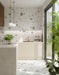 Kitchen featuring Fragmenta Light 60cm x 120cm terrazzo effect porcelain wall and floor tiles, showcasing a light neutral base with scattered multicoloured stone-style fragments, paired with white cabinetry, brass details and greenery.