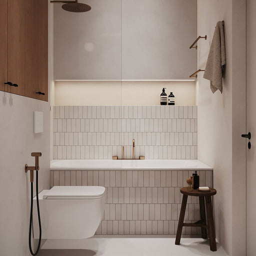 Bathroom interior featuring Fusion Bricks Artic White 6.5 × 20cm ceramic wall tiles, laid vertically with a clean, uniform look, paired with a built-in bath, brass fittings, soft lighting, and minimalist neutral styling.
