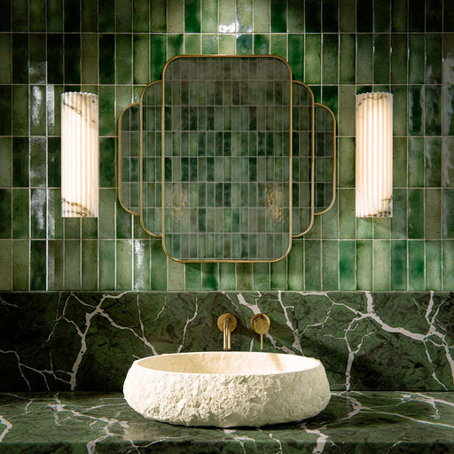 Bathroom vanity featuring Fusion Bricks Jade Green 6.5 × 20cm ceramic wall tiles, laid in a vertical pattern with rich green tonal variation, glossy finish, paired with a marble-effect surface, stone basin, and brass fittings.