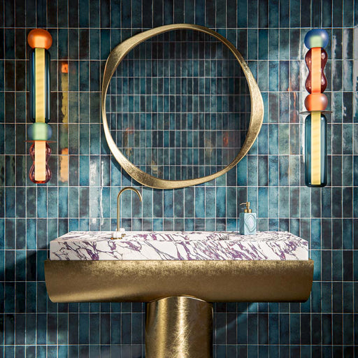 Bathroom vanity featuring Fusion Bricks Marine Blue 6.5 × 20cm ceramic wall tiles, laid vertically with deep blue tonal variation, glossy finish, paired with a marble basin, brass fixtures, and statement lighting for a bold, design-led look.